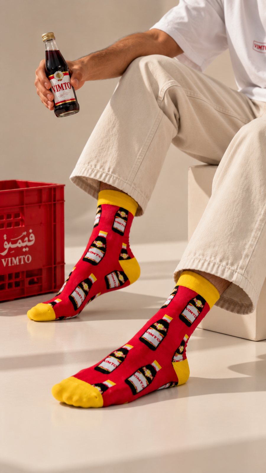 Vimto half crew socks by Socks Up, worn by a man holding a Vimto bottle next to a red crate