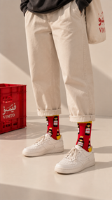 Vimto half crew socks by Socks Up, worn with cream trousers and white sneakers