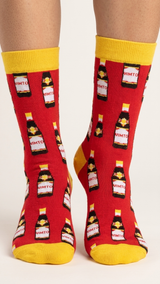 Red socks with yellow cuffs and heel featuring repeated Vimto bottle pattern.