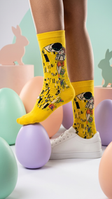 Yellow socks featuring The Kiss artwork design with black and colorful details.